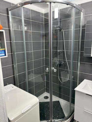 une douche avec une porte vitrée dans une salle de bain dans l'établissement Appartement cosy à 200 m de la plage à pied, à La Londe-les-Maures