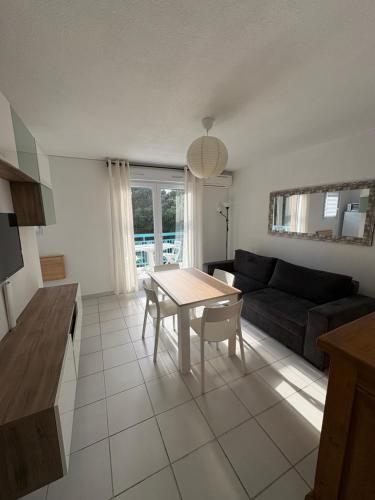 un salon avec une table et un canapé dans l'établissement Appartement cosy à 200 m de la plage à pied, à La Londe-les-Maures