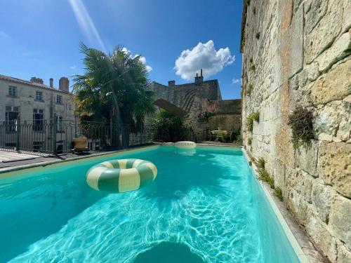 une piscine avec un ballon gonflable devant un bâtiment dans l'établissement Maison M - Spacieuse maison avec piscine privative, à Tonnay-Charente