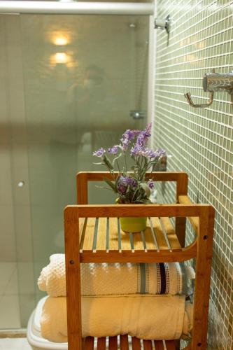 a bunch of towels on a rack with a vase of flowers at Apartamentos Hotel Marinas in Tamandaré