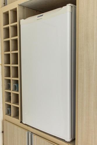 a white refrigerator in a cabinet in a kitchen at Apartamentos Hotel Marinas in Tamandaré