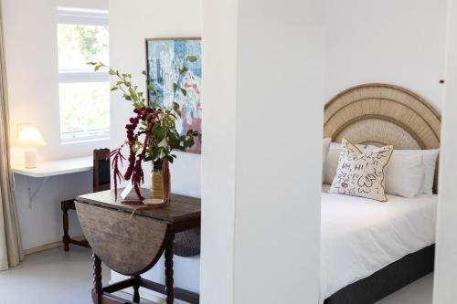 Stillewe Guest Cottages في Prince Alfreds Hamlet: غرفة نوم مع سرير وطاولة مع طاولة sidx sidx