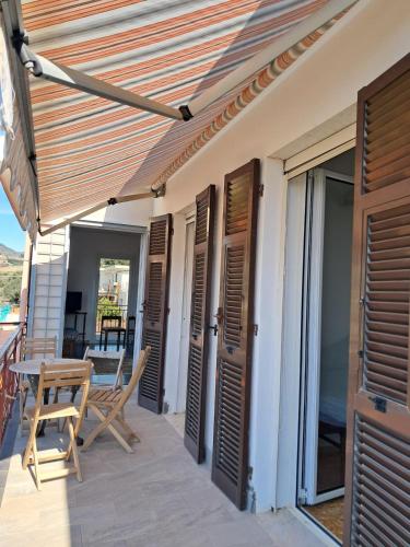 a patio with wooden doors and a table and chairs at VistaBlu Bussana in Arma di Taggia