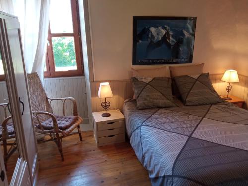 - une chambre avec un lit, une chaise et deux lampes dans l'établissement Le Chavannaclub, à Allevard