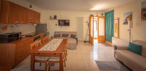 a kitchen and living room with a table and a couch at Nel Cuore del Borgo in Vico del Gargano