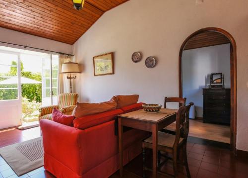 a living room with a red couch and a table at GuestReady - Domus Adepta Charming w/ Garden in Furnas