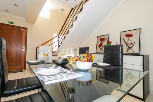 a dining room with a glass table and wine glasses at GuestReady - Casa do Parque in Ponta Delgada
