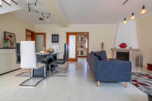 a living room with a blue couch and a table at GuestReady - Casa do Parque in Ponta Delgada