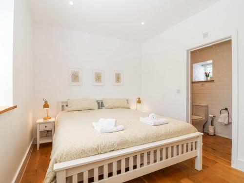 a bedroom with a bed with two towels on it at Old Orchard Barn in Saltash