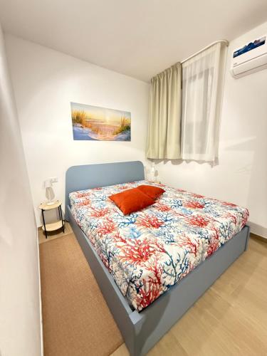 a bedroom with a bed with a colorful comforter at Custonaci 36 in Trapani