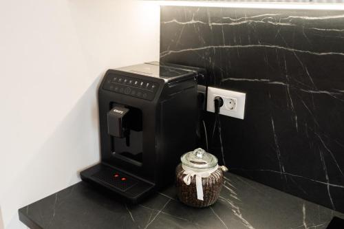 a coffee machine sitting on a counter next to a cup at Luxe Apartment - NEO TOWER in Suceava