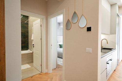 a white kitchen with a sink and a mirror at Luxe Apartment - NEO TOWER in Suceava