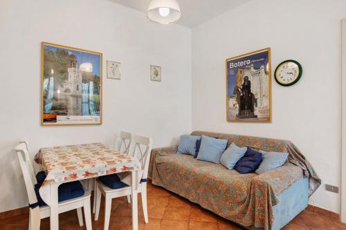 a living room with a couch and a table and a clock at Villa Chiara -Marina Di Pietrasanta in Marina di Pietrasanta