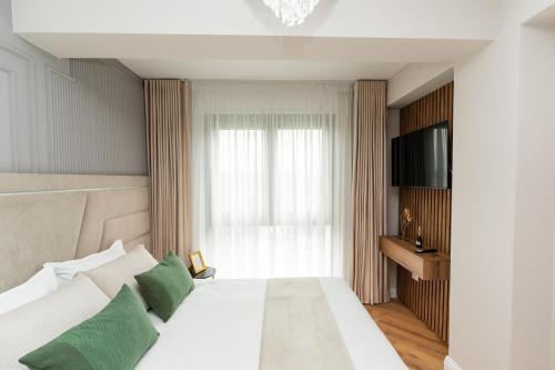 a bedroom with a large white bed with green pillows at Luxe Apartment - NEO TOWER in Suceava