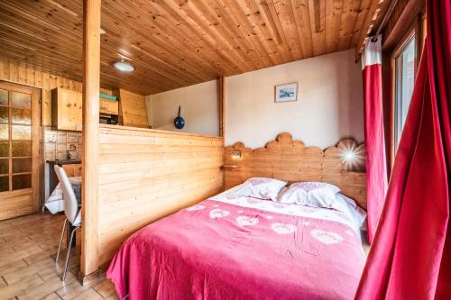 a bedroom with a bed with a red curtain at La Flèche d'Or in Châtel
