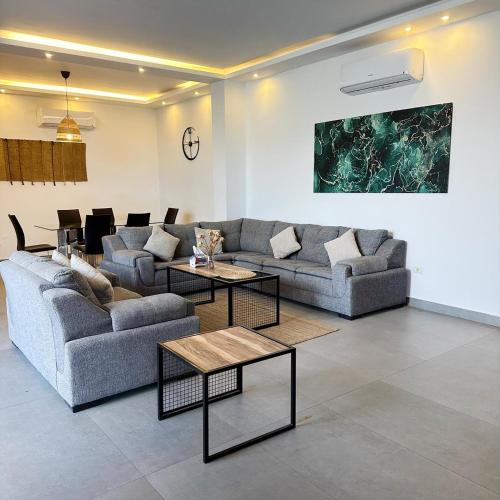 a living room with two couches and two tables at Bow Villa in Sowayma