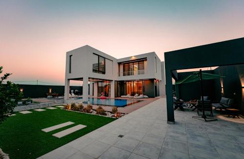 a large white house with a swimming pool at Bow Villa in Sowayma