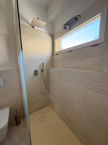 a bathroom with a shower with a glass door at Ersilia ed Ennio Apartment in Bellagio
