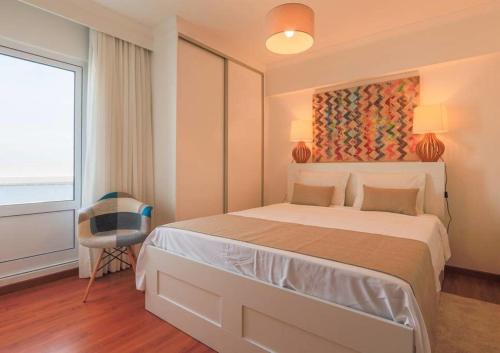 um quarto com uma cama e uma pintura na parede em GuestReady - Marina view top floor with terrace em Ponta Delgada