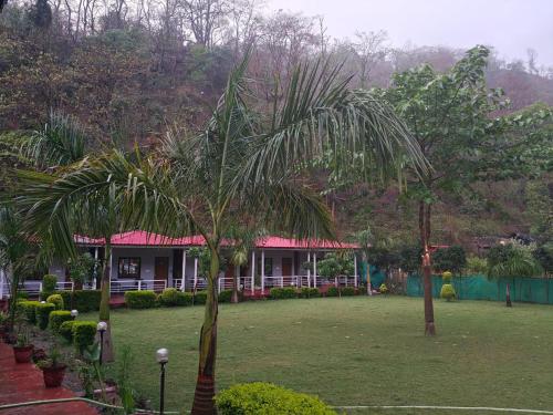 a house with two palm trees in a park at Ekantam Aspen By Yatri India Hospitality in Rishīkesh