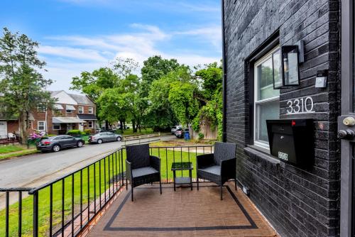 a balcony with two chairs and a sign on a building at Two-Bedroom House in Baltimore