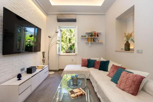 a living room with a white couch and a glass table at The Secret Garden - Courtyard & Private Pool Villa in Kalamata