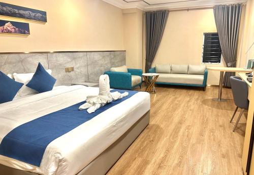 a hotel room with a bed with a towel animal on it at Meili Wanhe Hotel in Krong Poi Pet