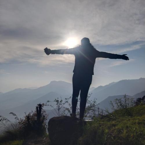 a man standing on top of a mountain with his arms outstretched at Cocoon Creek in Kodaikānāl