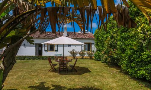 a table and chairs in the yard of a house at Domus Adepta Family w Garden in Furnas