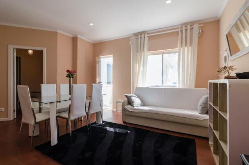 a living room with a table and a white couch at Alvor Sol in Alvor