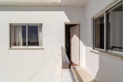 a white building with a door and windows at Alvor Sol in Alvor