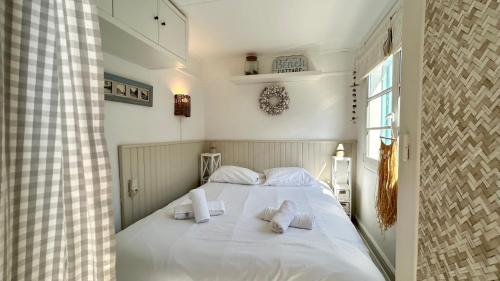 une chambre avec un lit blanc avec des oreillers blancs dans l'établissement Cabane du Pêcheur, maison avec extérieur, au Crotoy