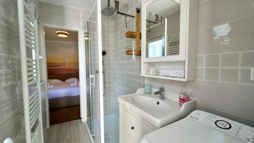une petite salle de bain avec un lavabo et une douche dans l'établissement Cabane du Pêcheur, maison avec extérieur, au Crotoy