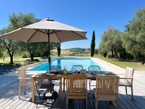 - une table avec un parasol à côté de la piscine dans l'établissement Cottage in French Tuscany, à Roquemaure