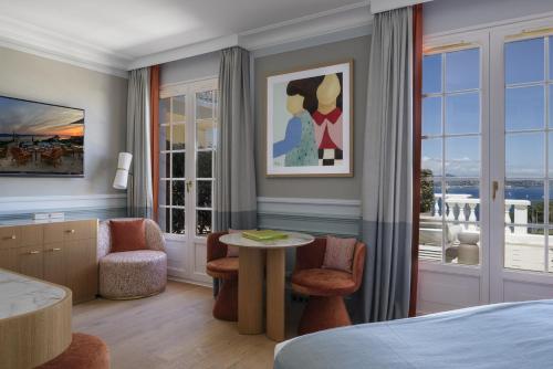 a hotel room with a bed and a table and chairs at Althoff Hotel Villa Belrose in Saint-Tropez