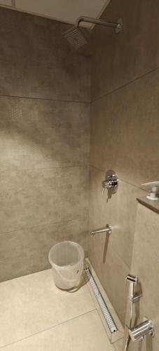 a bathroom with a bucket in the corner of a shower at Alite Enclaves Fully furnished apartments in Trichūr