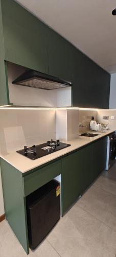 a green and white kitchen with a stove top oven at Alite Enclaves Fully furnished apartments in Trichūr