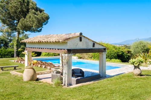 un gazebo à côté d'une piscine dans l'établissement Le Mas Des Serens, à La Gaude