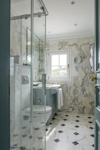 a bathroom with a glass shower and a toilet at Althoff Hotel Villa Belrose in Saint-Tropez