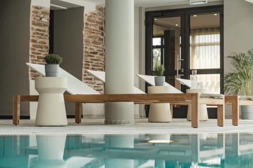 a lobby with a pool and tables and chairs at Naturhotel Sachsenbaude Oberwiesenthal - Indoor-Pool & Outdoor-Whirlpool in Kurort Oberwiesenthal