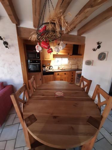une table de salle à manger avec des chaises et une cuisine dans l'établissement La Basse Bédinière, à Crouy-sur-Cosson
