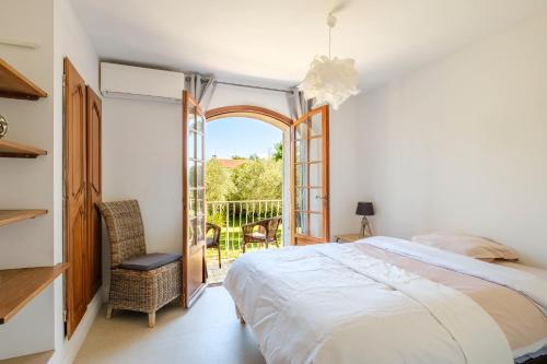 Un dormitorio con una cama grande y un balcón. en Le Mas Des Serens, en La Gaude