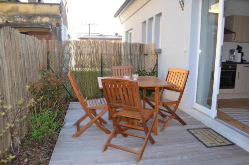une table et des chaises en bois sur une terrasse dans l'établissement Gîte 2 - l'Alsacienne, à Mittelwihr
