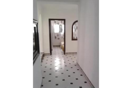 a hallway with a tile floor and a room with a door at Plage Alamine Fnideq Tamuda bay in Fnidek