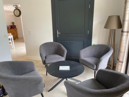 a living room with three chairs and a table at Favau in Villeneuve-sur-Lot