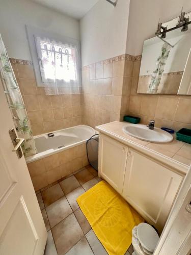 une salle de bain avec un lavabo, une baignoire et des toilettes dans l'établissement Logement A Nepita splendide vue mer avec piscine, à Porto-Vecchio