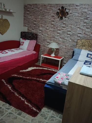 a room with a bed and a table with a couch at Vila Petrov in Lukavica
