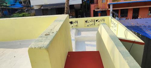 a yellow fence with a red ramp next to a building at Thillai Aura Homestay in Chidambaram