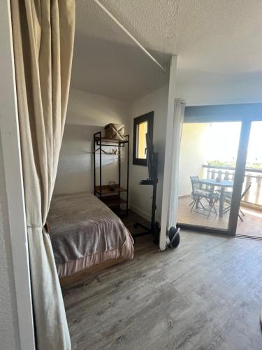 une chambre avec un lit et un balcon dans l'établissement Ecrin du Sud, au Barcarès