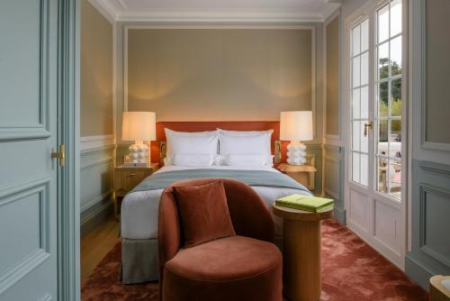 a bedroom with a bed and a chair at Althoff Hotel Villa Belrose in Saint-Tropez